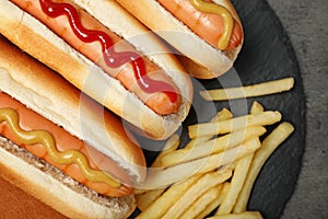 Delicious hot dogs and french fries on slate plate