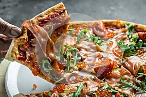 Delicious hot pizza with salmon, red caviar, tomatoes and aragula ready to eat. banner, menu, recipe place for text, top