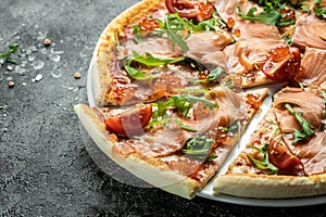 Delicious hot pizza with salmon, red caviar, tomatoes and aragula ready to eat. banner, menu, recipe place for text, top view