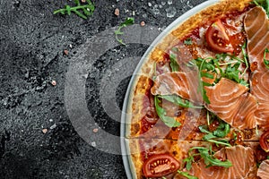 Delicious hot pizza with salmon, red caviar, tomatoes and aragula ready to eat. banner, menu, recipe place for text, top view