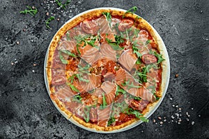 Delicious hot pizza with salmon, red caviar, tomatoes and aragula ready to eat. banner, menu, recipe place for text, top view