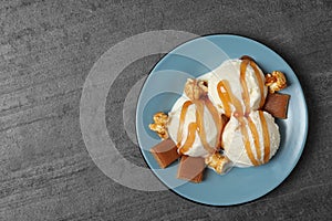 Delicious ice cream with caramel  on grey table, top view. Space for text