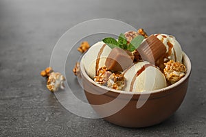 Delicious ice cream with caramel and popcorn in dessert bowl on table