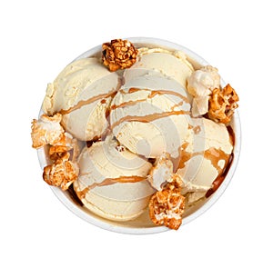 Delicious ice cream with caramel popcorn and sauce in dessert bowl on white background