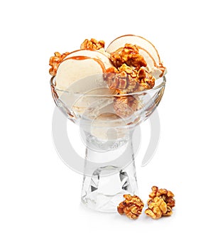 Delicious ice cream with caramel popcorn and sauce in glass dessert bowl on white