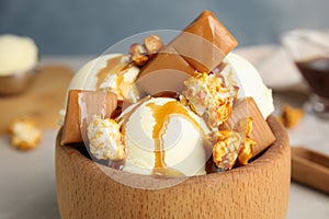 Delicious ice cream with caramel, popcorn and sauce served on table