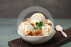 Delicious ice cream with caramel, popcorn and sauce on table