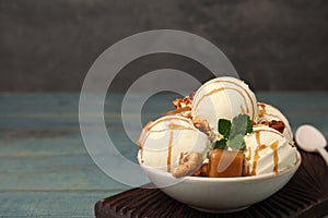 Delicious ice cream with caramel, popcorn and sauce on table. Space for text