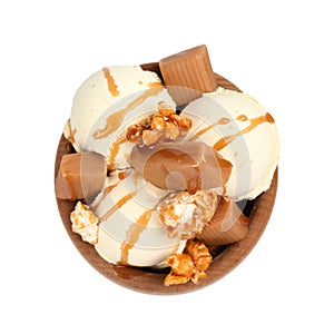 Delicious ice cream with caramel and popcorn in wooden bowl on white background