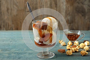 Delicious ice cream with caramel topping in dessert bowl