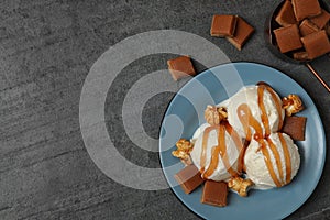 Delicious ice cream with caramel topping on grey table, flat lay