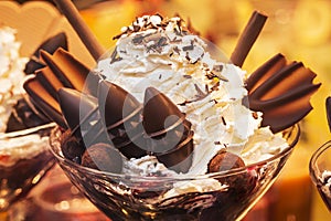 Delicious  ice cream with fruits, chocolate, nuts in glass bowl. Close up