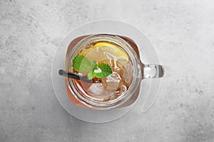 Delicious iced tea with lemon and mint on grey table, top view