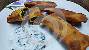 Delicious Indian snack called as kothimbir vadi seasoned with curd chutney. photo