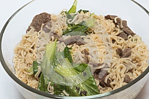 Delicious instant noodle in bowl on white