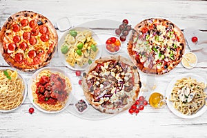 Delicious Italian food table scene, top down view on a white wood background