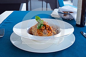 Delicious Italian pasta with seafood in tomato sauce in a white plate. Delicious dinner at the restaurant.