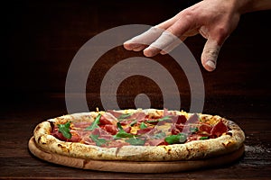 Delicious italian pizza margherita served on wooden plate over rustic wooden background