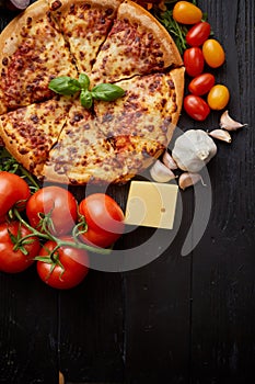 Delicious italian pizza served on black wooden table