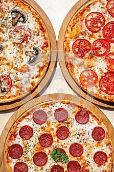 Delicious italian pizzas served on wooden table.