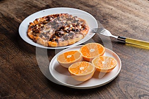 Delicious italian pizzas served on wooden table wiht orange