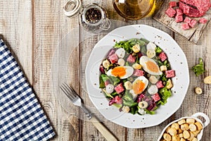Delicious Italian salad with salami, egg, crostini and mozzarella photo