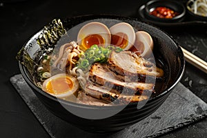 Delicious Japanese ramen noodle soup with pork, soft-boiled eggs, and garnishes