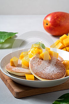 Delicious Japanese souffle pancake with dice mango and jam on white table background