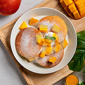 Delicious Japanese souffle pancake with dice mango and jam on white table background