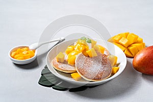 Delicious Japanese souffle pancake with dice mango and jam on white table background