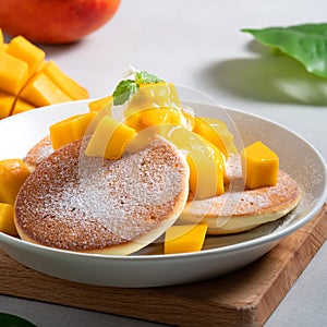 Delicious Japanese souffle pancake with dice mango and jam on white table background