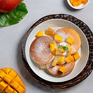 Delicious Japanese souffle pancake with dice mango and jam on white table background