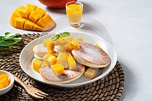 Delicious Japanese souffle pancake with dice mango and jam on white table background