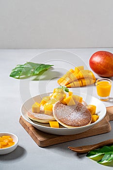 Delicious Japanese souffle pancake with dice mango and jam on white table background