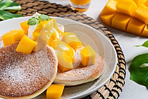 Delicious Japanese souffle pancake with dice mango and jam on white table background