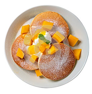 Delicious Japanese souffle pancake with dice mango and jam on white table background