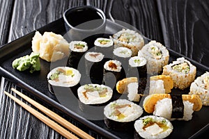 Delicious Japanese sushi rolls large set with seafood, vegetables, tofu and tamago closeup. horizontal