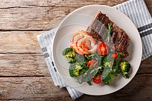 Delicious juicy barbequed steak and prawns with vegetable salad