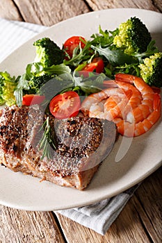 Delicious juicy barbequed steak and prawns with vegetable salad