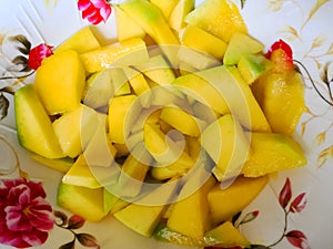 Delicious and juicy chopped ripe mango served on a white plate