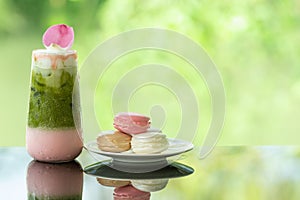 Delicious juicy fresh milk green tea on glass table Blurred leaf reflection background