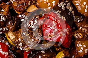 Delicious juicy fresh salad of baked eggplant, tomatoes, sweet peppers, sesame seeds