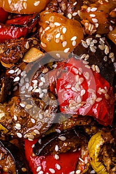 Delicious juicy fresh salad of baked eggplant, tomatoes, sweet peppers, sesame seeds