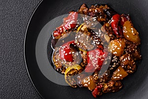 Delicious juicy fresh salad of baked eggplant, tomatoes, sweet peppers, sesame seeds