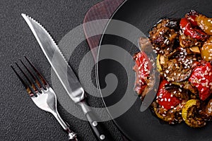 Delicious juicy fresh salad of baked eggplant, tomatoes, sweet peppers, sesame seeds