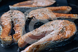 Delicious and juicy pieces of salmon are grilled on a special non-stick Teflon lining. Family barbecue in the backyard of a