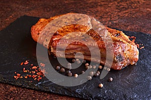 Delicious and juicy steak on a stone table surrounded by spices