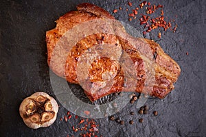 Delicious and juicy steak on a stone table surrounded by spices