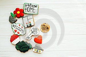 Delicious key, house, plant,window,heart and welcome sign cookies on white wood, flat lay with space for text. Dream home concept