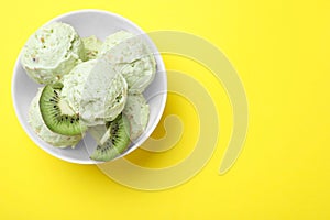 Delicious kiwi ice cream on yellow background, top view. Space for text